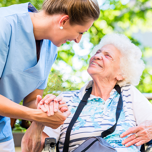 Friendly caregiver holds a woman's hand